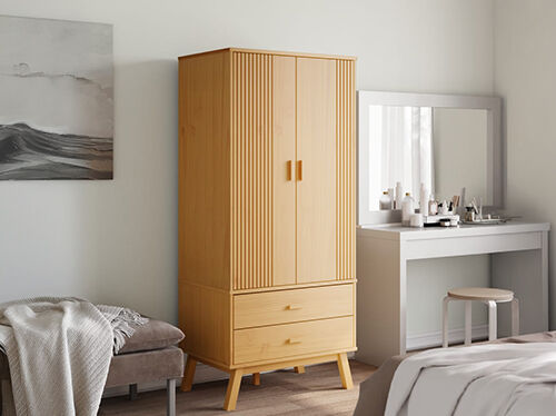 Tall wooden cabinet with doors and drawers, in a styled bedroom. Click to see the products in the collection.