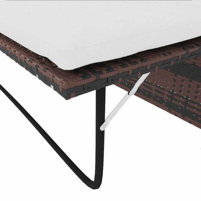 Close-up of outdoor table height with white cushion resting on wicker edge and metal support.