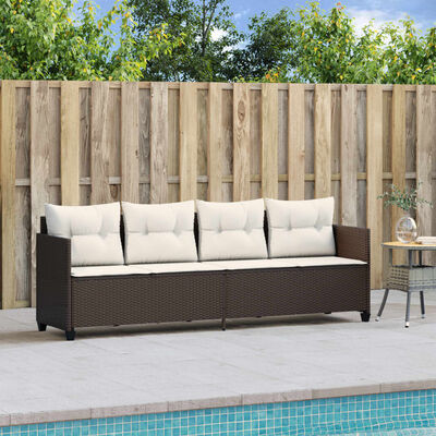 Brown outdoor wicker sofa with beige cushions next to a small table by poolside.