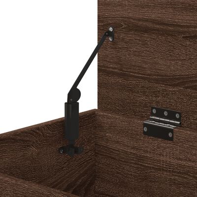 Interior corner of wooden storage chest showing gas strut and metal hinge