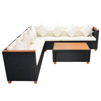 L-shaped black wicker outdoor sectional with beige cushions and a rectangular coffee table.