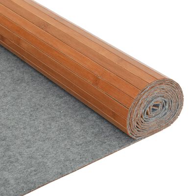 Rolled bamboo mat with gray underside facing forward on a gray surface.