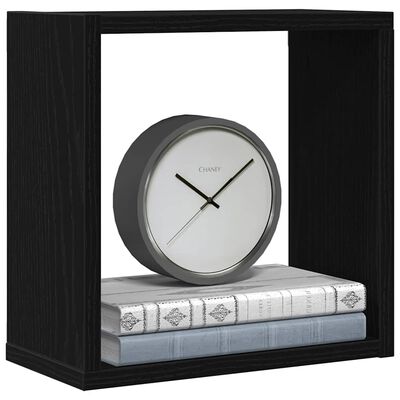 Close-up of a black cube shelf containing a round clock and books
