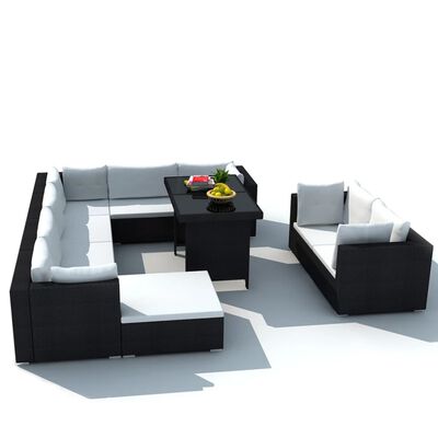Open-air sectional seating arrangement with black wicker frames and white cushions and a central table.