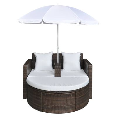 Round wicker sectional with white cushions and two back cushions under a white umbrella.