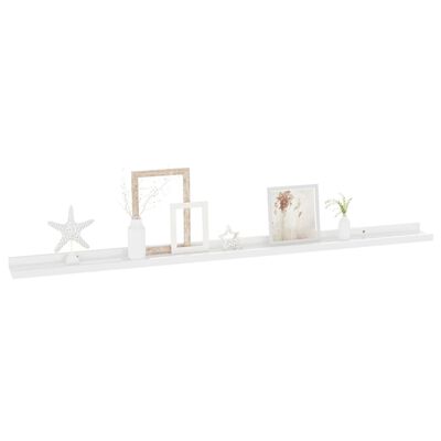 A long white shelf with decorative photos and ornaments arranged along a wall