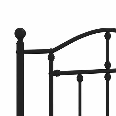 Close-up of a black metal bed post with ball finial and curved top rail, showing joinery.