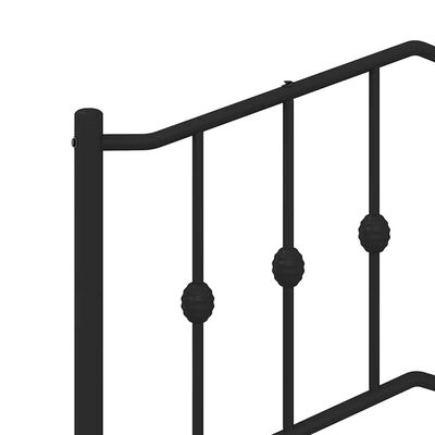 Close-up of black metal bed railing with vertical bars and decorative round nodes.