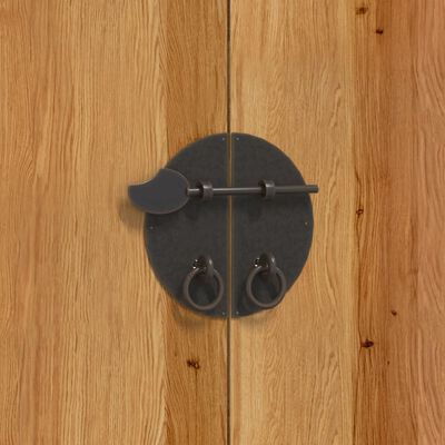 Close-up of round black metal latch or lock on wooden cabinet door