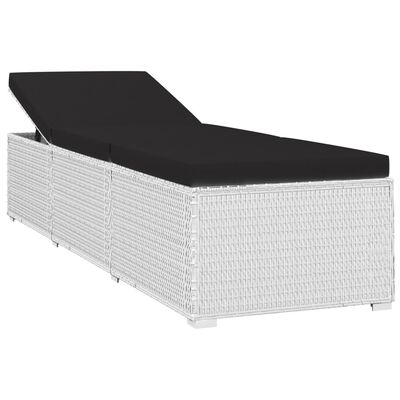 White wicker outdoor sofa with black cushions in a lounge arrangement.