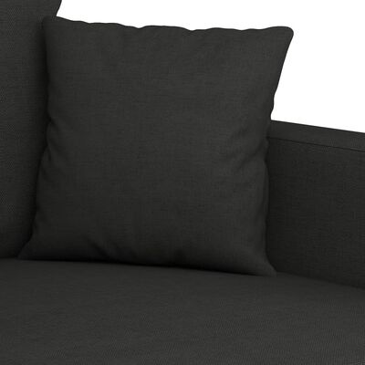 Close-up of a black cushion on a dark sofa showing fabric texture.