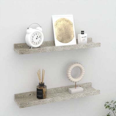 Two concrete shelves mounted on a wall with various decorative items including an alarm clock and bottles