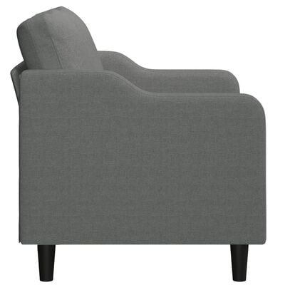 Side view of a grey armchair showing curved arm and fabric upholstery on legs.