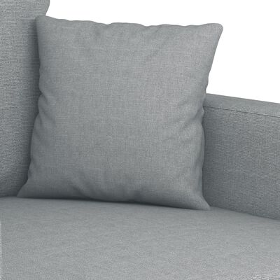 Close-up of a grey cushion placed on a grey fabric sofa.