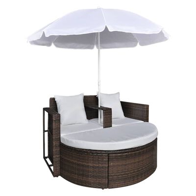 Round wicker outdoor sofa with white cushions and umbrella, side armrests and cushions.