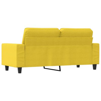 Rear/side view of the yellow sofa showing legs and back cushions in a different angle.