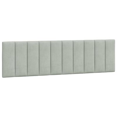 Close-up of long rectangular padded headboard tufted panels in light gray upholstery.