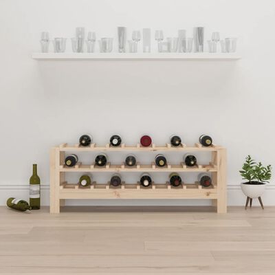Wooden rack with two rows of wine bottles, placed against a white wall with a plant on the right