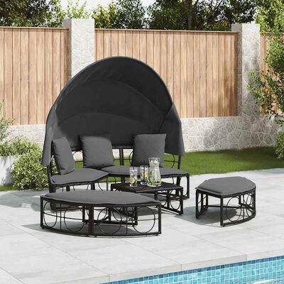 Round outdoor daybed with canopy and matching side tables arranged on patio by pool.