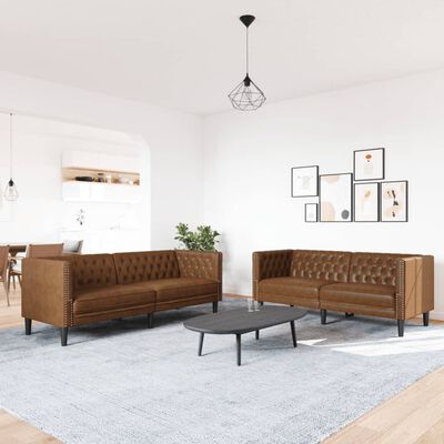 Brown tufted leather sofas arranged in a living room with a round coffee table and art on the wall.