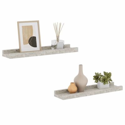 Two floating concrete shelves with framed art, a diffuser, and decorative objects arranged on them
