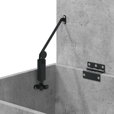 Close-up of metal hinge and hydraulic stay supporting lid of concrete storage chest