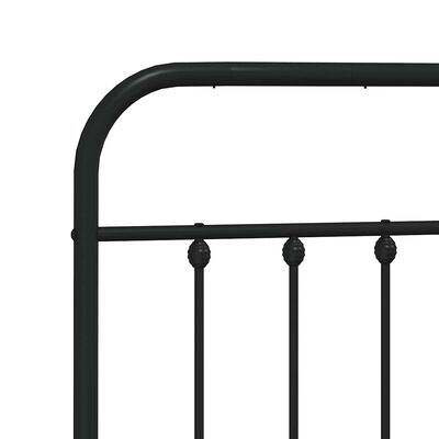 Close-up of the curved corner post and vertical bars of a black metal bed frame.