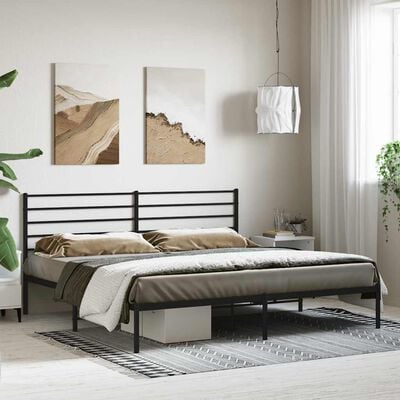 Bedroom setup with black metal bed frame and headboard with artwork