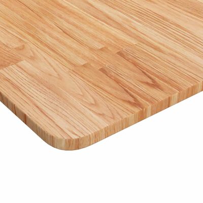 Corner close-up of wooden cutting board surface showing end grain and rounded corner