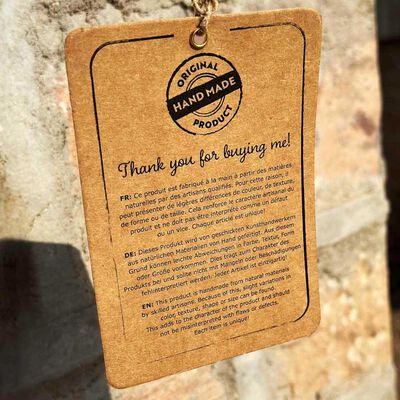 Tag reading handmade product, original handmade, with descriptive text in multiple languages.