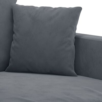 Close-up of a grey throw pillow on the sofa with armrest in background.