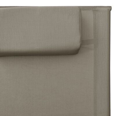 Close-up of the beige fabric surface and stitching near the edge of the chaise lounge.