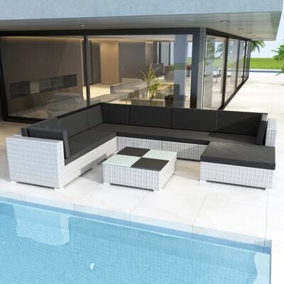 Outdoor wicker sectional sofa set with black cushions around a matching coffee table beside a pool