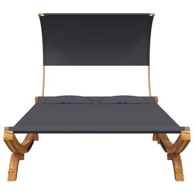 Front view of a double bed with dark gray mattress and two pillows, on a carved wooden frame with canopy support.