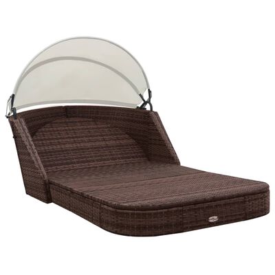 Brown wicker outdoor daybed with white cushion and canopy