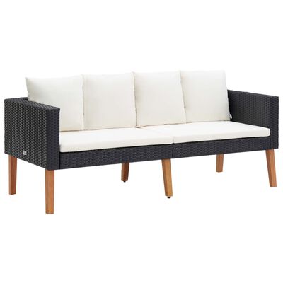 Three-seat dark woven outdoor sofa with white cushions and wooden legs.