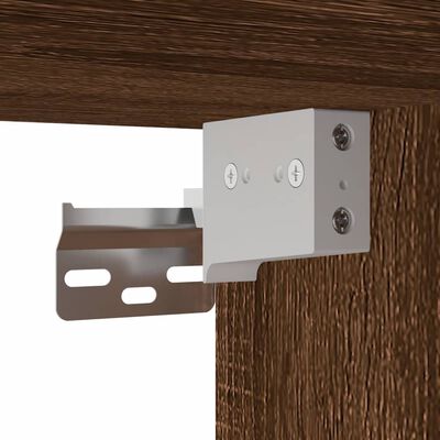 Close-up of metal mounting bracket attached to a wood panel for furniture assembly.