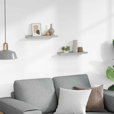 Living room wall with two small floating concrete shelves holding framed art and small objects