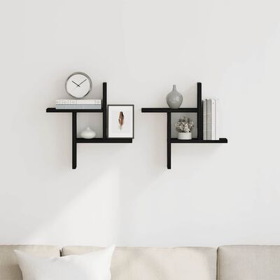 Two black wall shelves mounted on a white wall with decorative items and books