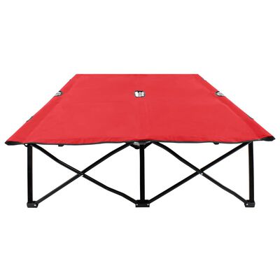 Collapsed red camping table showing double-X frame underside